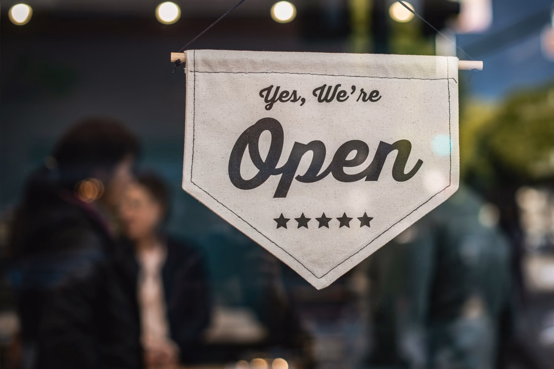 Open sign in a small business storefront window, representing LocalBusiness schema markup
