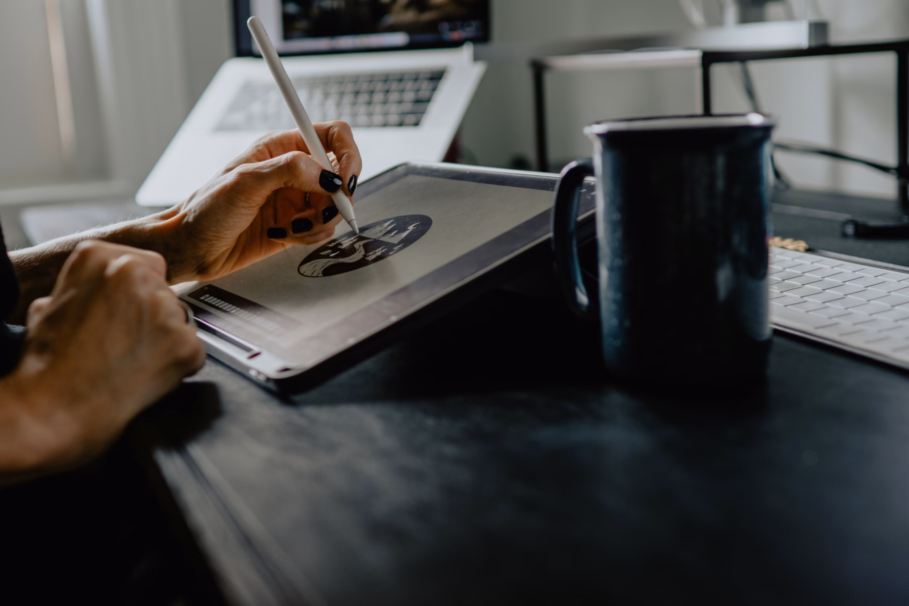 Designer sketching a logo concept on a tablet at a workspace
