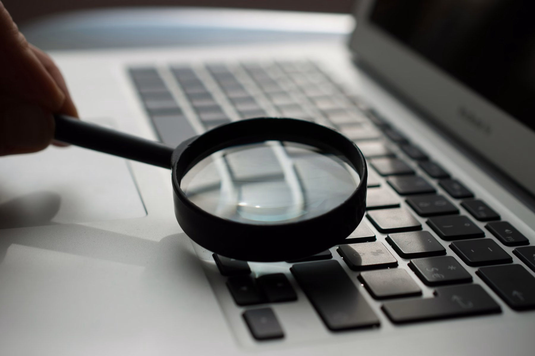 Magnifying glass over a laptop, representing testing and validating schema markup