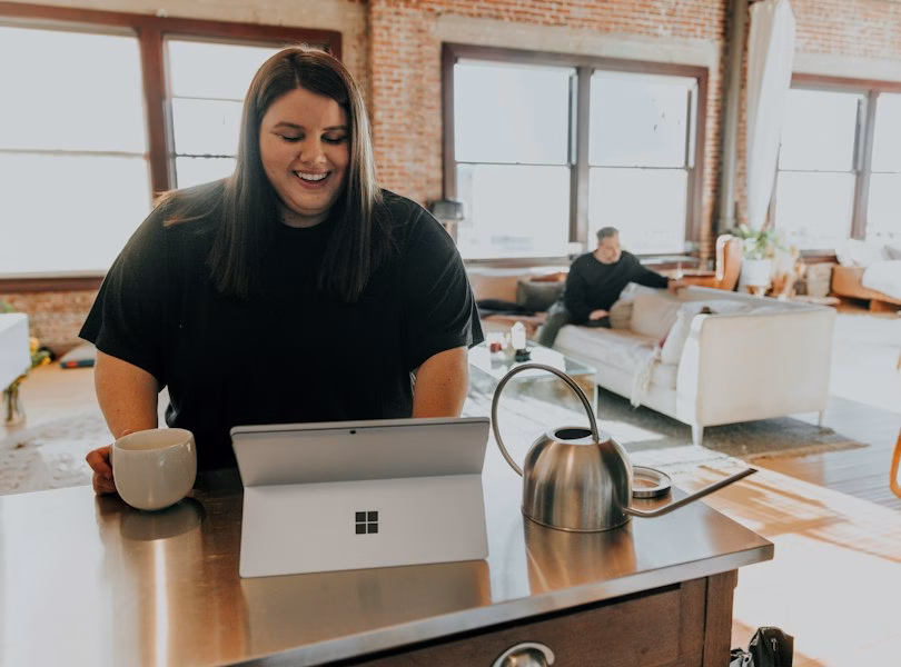 Small business owner smiling while working on a laptop