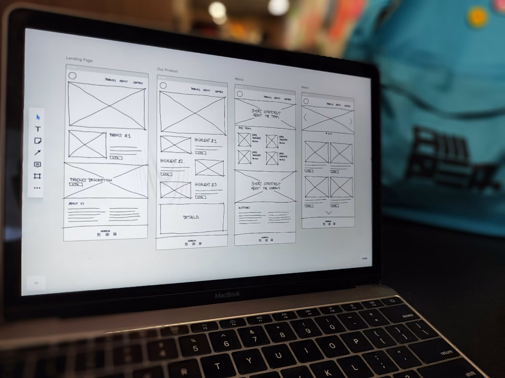 Laptop showing a grey-box wireframe layout for a website page