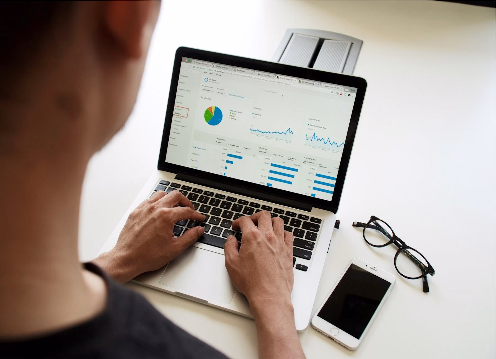 Marketer reviewing charts on a laptop while researching competitor ads