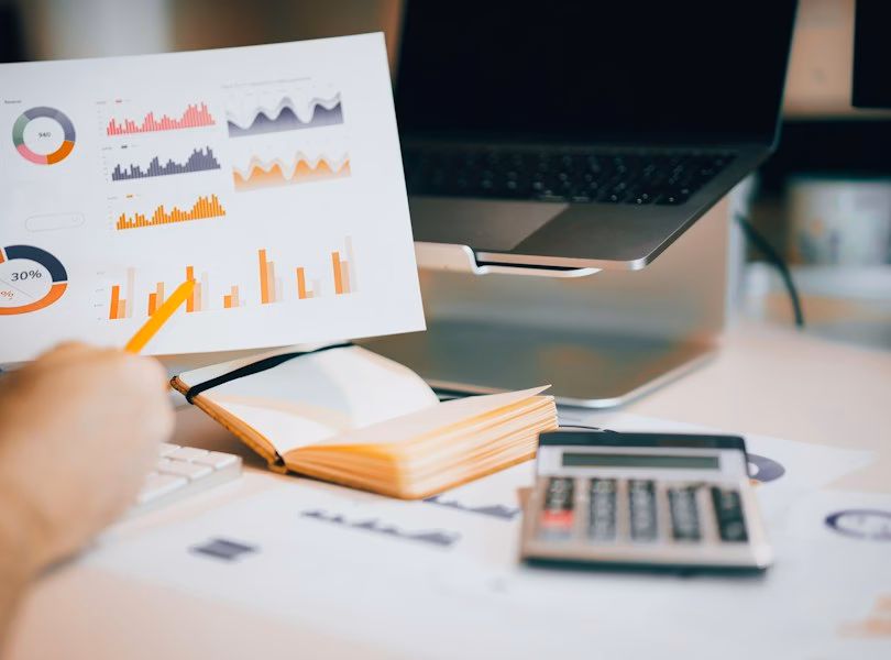 Printed project report with charts and a calculator on a desk