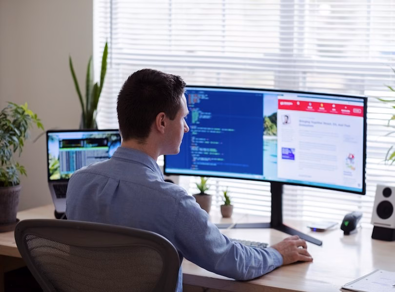 Designer reviewing a website layout on two monitors