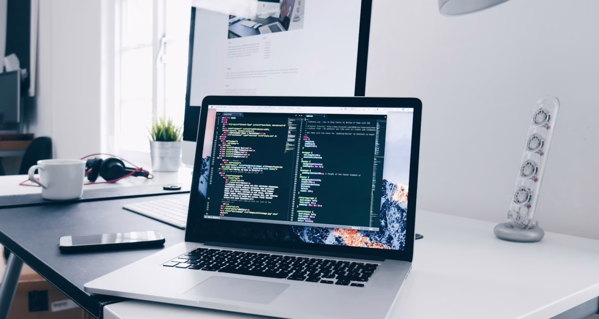 Laptop showing website code on a web developer's desk